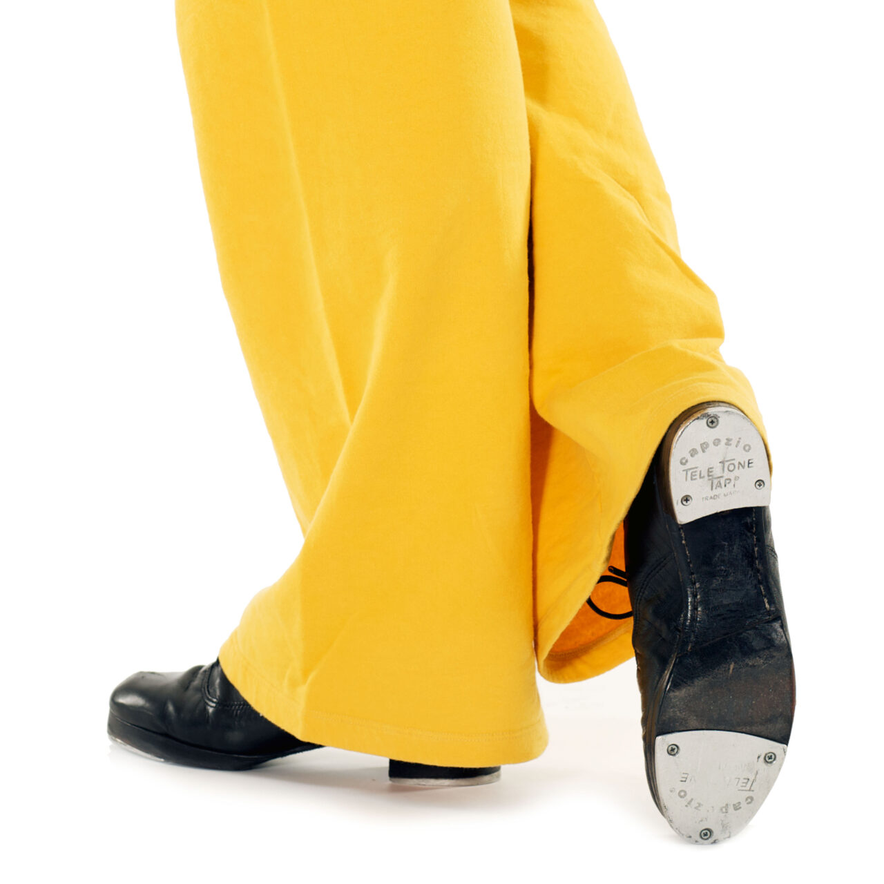 Tap shoe and yellow trousers in motion